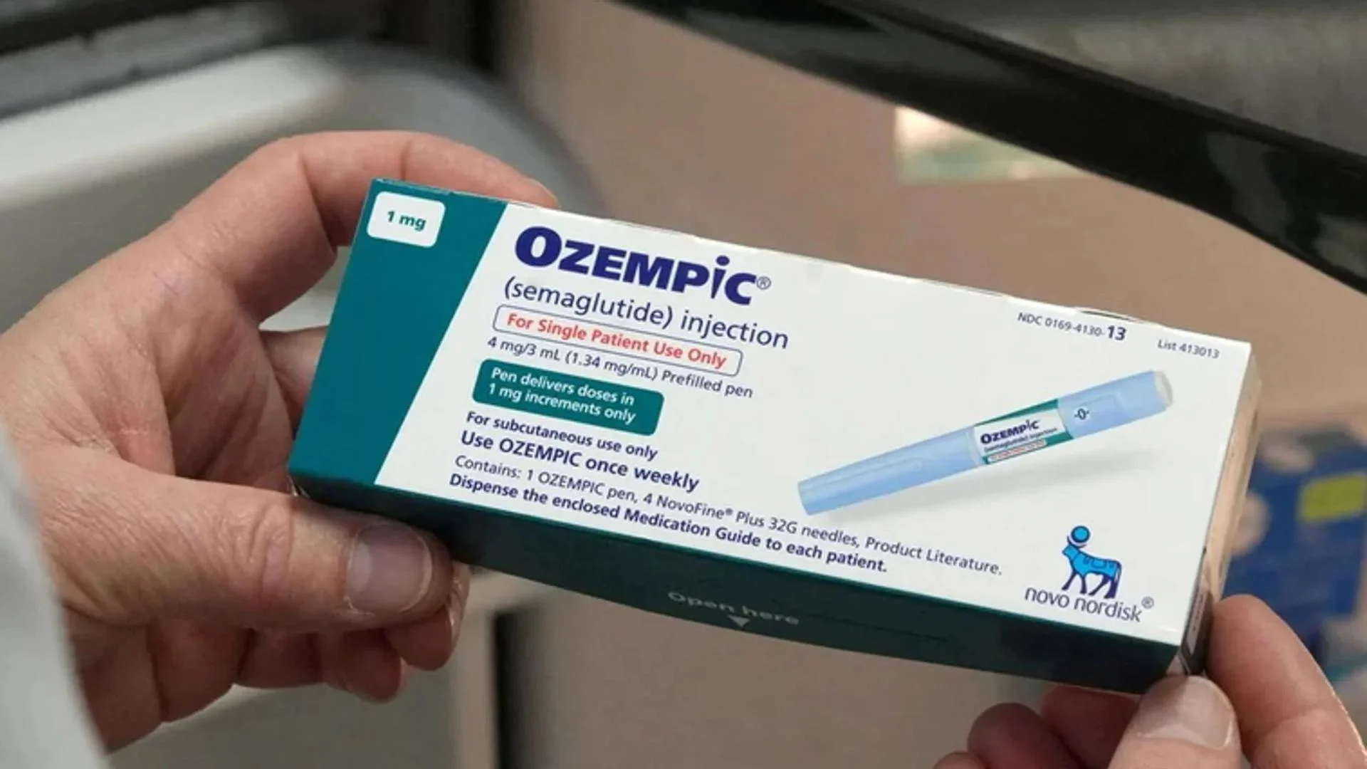 una confezione chiusa di ozempic stretta tra le mani di un uomo