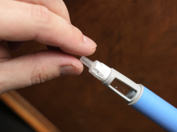 due dita che si stringono attorno all'estremità di una pennetta che contiene il principio attivo dei farmaci per dimagrire